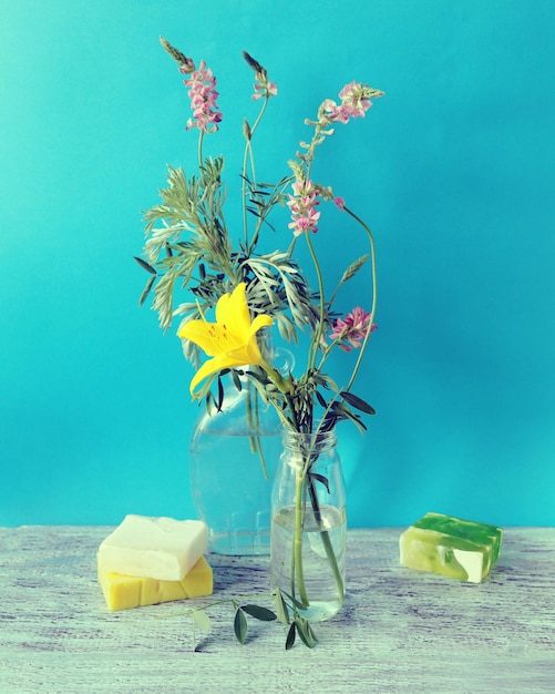 Bouquets and tinctures of medicinal herbs in glass containers soap on a wooden table spa