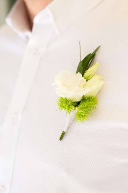 Boutonniere on chest close up. The groom's shirt for the wedding ceremony