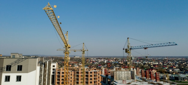 Bouw en constructie van hoogbouw, de bouw met arbeidsmiddelen en arbeiders. Bekijk van bovenaf, van bovenaf.