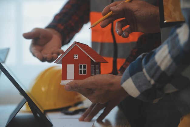 Foto bouw- en structuurconcept van ingenieurs- of architectenbijeenkomst voor projectwerk met partner- en technische hulpmiddelen voor modelbouw en blauwdruk in werklocatiecontract voor beide bedrijven