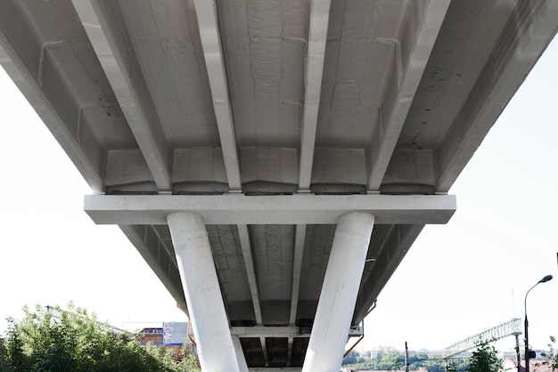 Bouw van een betonnen verkeersbrug ondersteund door pilaren, van onder naar boven gezien. Onder de brug, perspectief