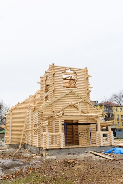 Bouw van een christelijke kerk gemaakt van met hout behandelde stammen met de hand zonder spijkers