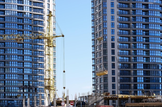 Bouw van kantoorgebouwen een bouwkraan tilt materialen op bouwers werken foto van hoge kwaliteit