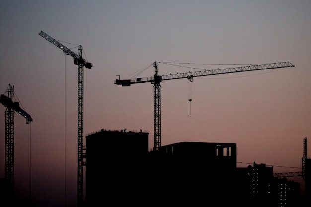 Bouw van nieuwe residentiële hoogbouw tegen de achtergrond van een avondrood