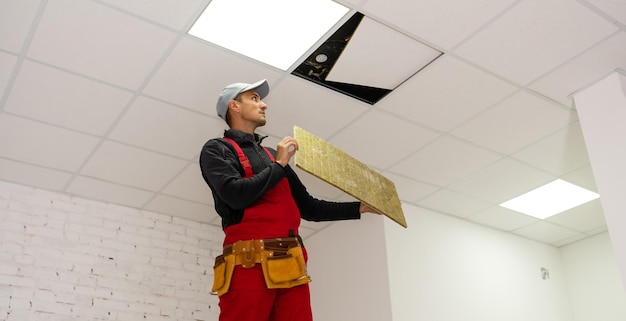 Bouwer die plafondpaneel vervangt, werkend, plafond armstrong.