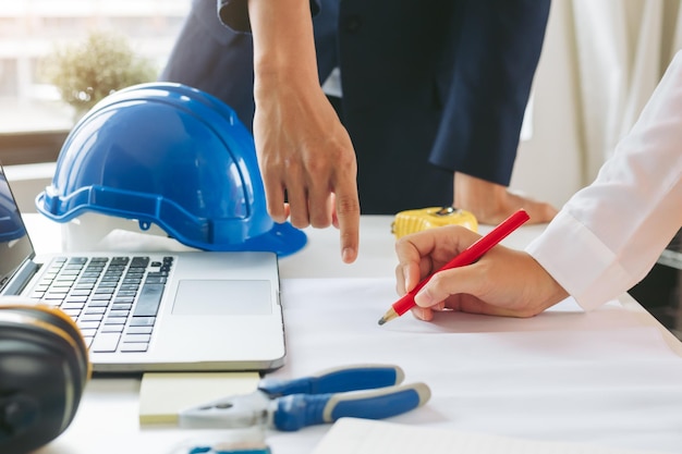 Foto bouwer jonge ingenieur man en architect vrouw bespreken de bouw van een plan om het project te volgen om een industriële fabriek ter plaatse te bouwen. arbeidersconcept.