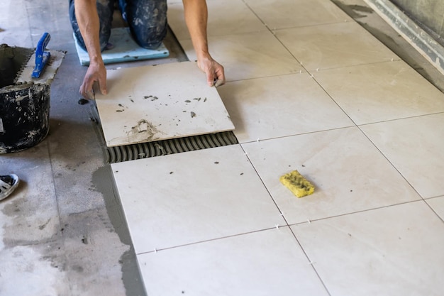 Foto bouwer legt de tegels op de vloer, de reparatie