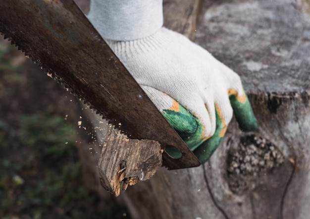 Bouwer zaagt houten stok met handzaag