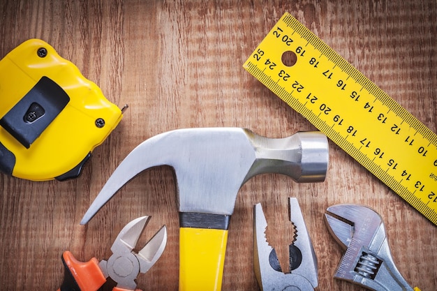 Bouwgereedschap op houten plank hamer tangen tang moersleutel tapeline liniaal