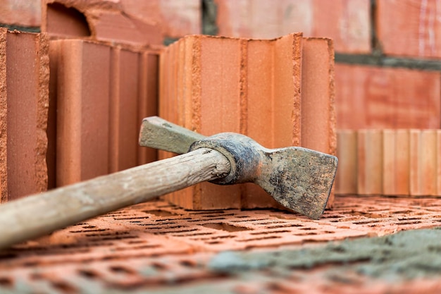 Bouwgereedschap voor het leggen van stenen en blokken Metselaarsgereedschap hamer spatel troffelhandschoenen Handgereedschap op de achtergrond van metselwerk