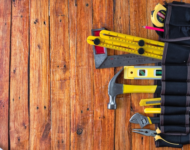 Bouwhulpmiddelen in toolbelt op houten achtergrond