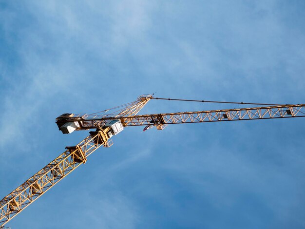 Bouwkranen hoog in de lucht met bewolkte wolken