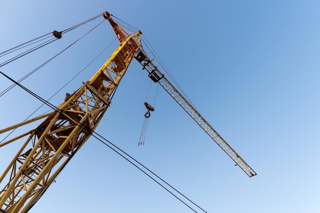 Foto bouwkranen op een blauwe achtergrond huisbouw appartementengebouw met steiger