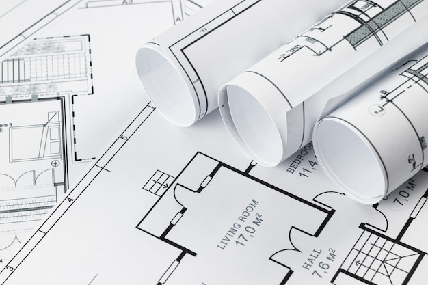 Bouwkundige constructietekeningen in een rol gedraaid, bouwprojecten op papier.