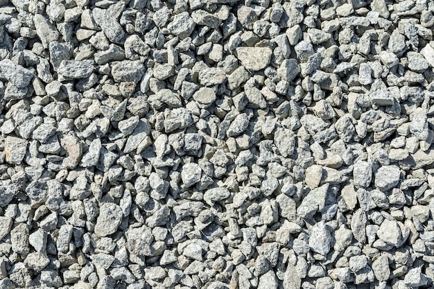 Bouwmaterialen voor wegwerkzaamheden De textuur van grijze gebroken steen of puin als een natuurlijke achtergrond