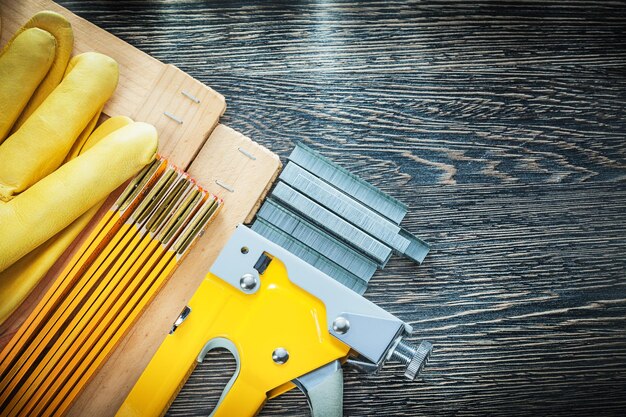Bouwnietmachine nietjes houten meterplanken beschermende handschoenen