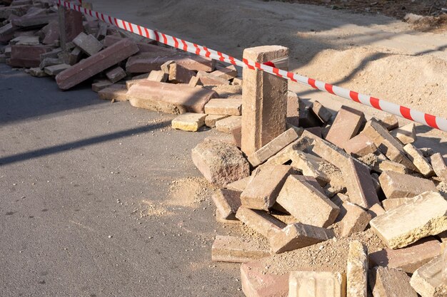 Bouwplaats met een stapel bakstenen en waarschuwingsband om het gebied voor veiligheid te markeren