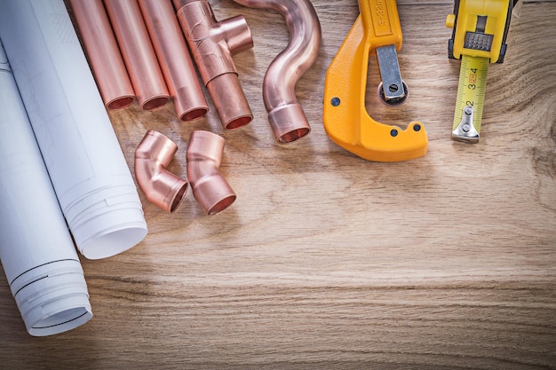 Bouwplannen tape lijn waterleidingsnijder hulpstukken op houten plank sanitair concept