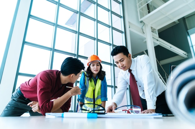 Foto bouwteam met zakenman ingenieur en architect is aan het brainstormen op werktafel met kopieerruimte aan de zijkant