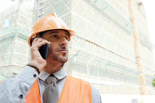 Bouwvakker die telefoongesprek maakt