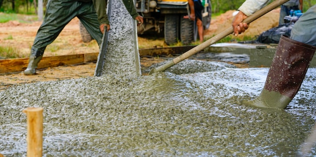 Bouwvakker giet nat beton op de bouwplaats Bouwvakker werkt met klaar