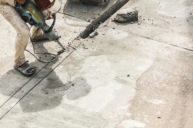 Bouwvakker met behulp van jackhammer boren betonnen oppervlak