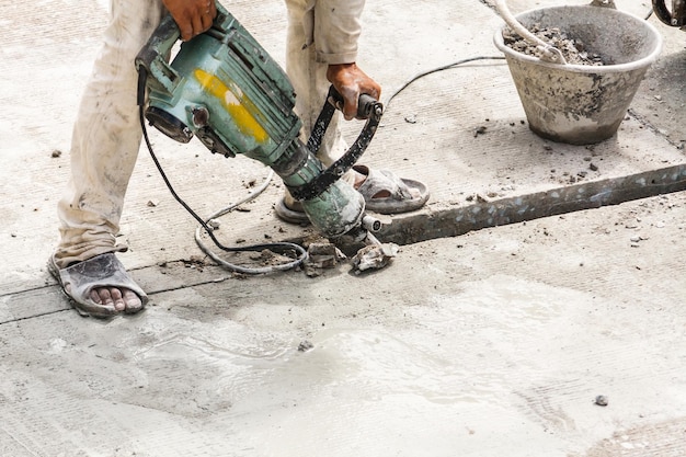 Bouwvakker met behulp van jackhammer boren betonnen oppervlak