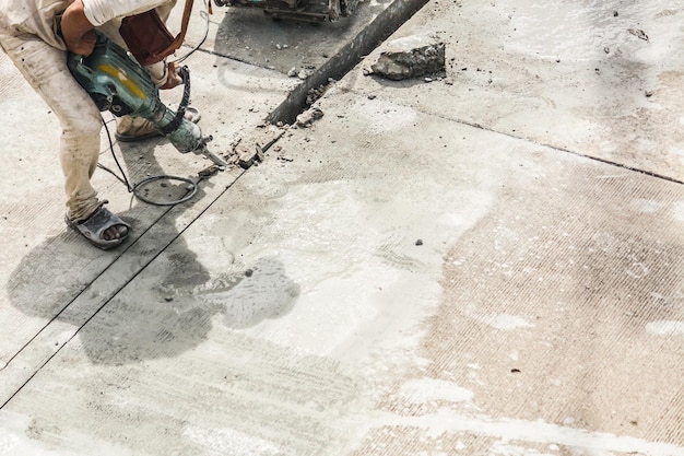 Bouwvakker met behulp van jackhammer boren betonnen oppervlak