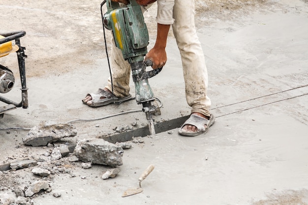 Bouwvakker met behulp van jackhammer boren betonnen oppervlak