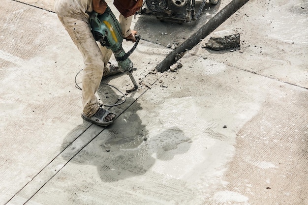 Bouwvakker met behulp van jackhammer boren van betonnen oppervlak