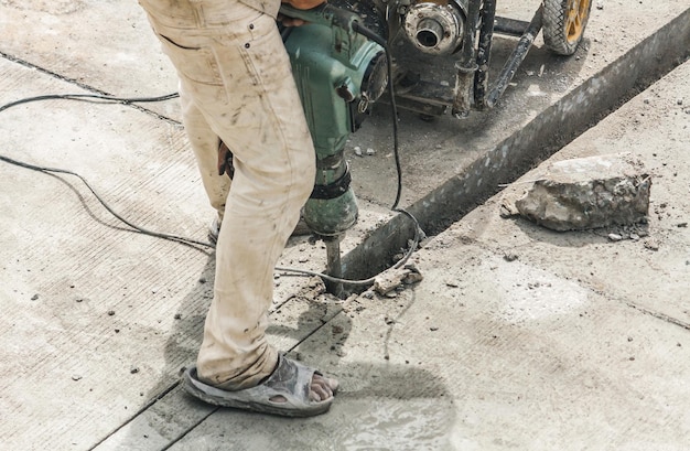 Bouwvakker met behulp van jackhammer boren van betonnen oppervlak