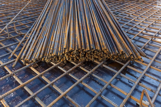 Bouwvakkers die stalen wapeningsstaaf fabriceren op de bouwplaats. De wapeningsstaaf werd aan elkaar vastgemaakt met behulp van kleine draad.