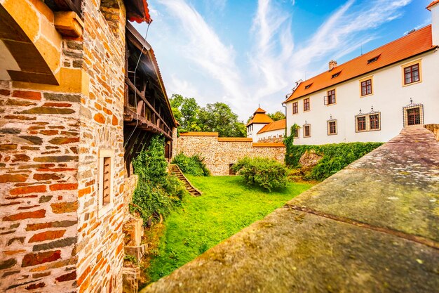 Bouzov castle Fairytale castle in czech highland landscape Castle with white church high towers red roofs stone walls Czech republic