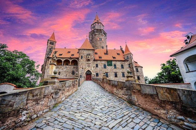 Bouzov castle Fairytale castle in czech highland landscape Castle with white church high towers red roofs stone walls Czech republic