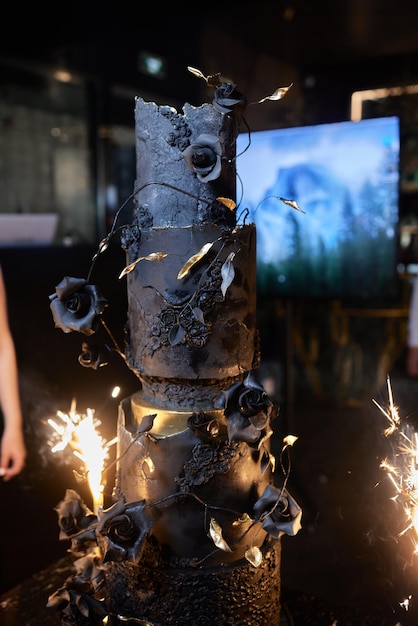 Foto boven brandende kaarsen staat vuurwerk in een taart en hangt er een hand overheen