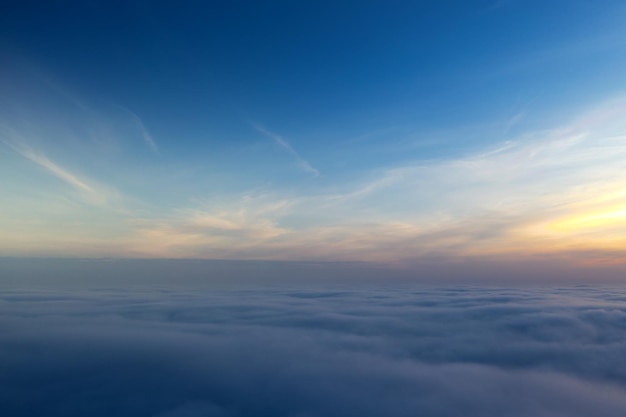 Boven de wolken zonsopgang of zonsondergang Heldere lucht boven de mist Uitzicht vanuit het vliegtuig Concept reizen vakantie ontspannen