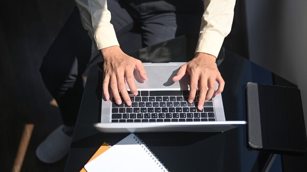 Boven geschoten man typen op laptopcomputer.