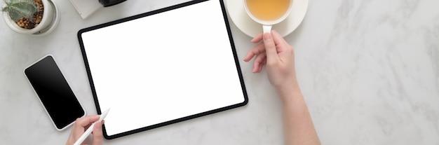 Boven geschoten van vrouwelijke freelancer die aan modeltablet aan marmeren lijst werken