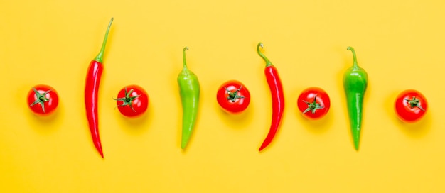 Boven uitzicht op Chili peper en tomaten op gele achtergrond