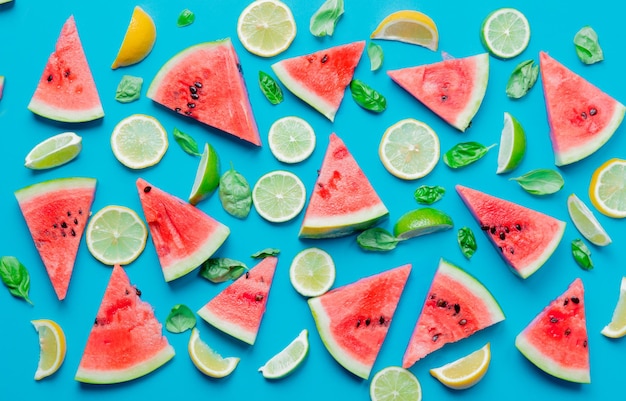 Boven uitzicht op gesneden citroenen en limoenen met watermeloen op blauwe achtergrond