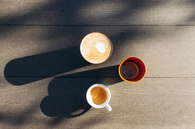 Bovenaanzicht 3 kopjes koffie op tafel Cappuccino Espresso Americano