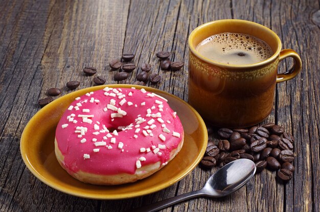 bovenaanzicht aardbei donut in plaat met kopje koffie