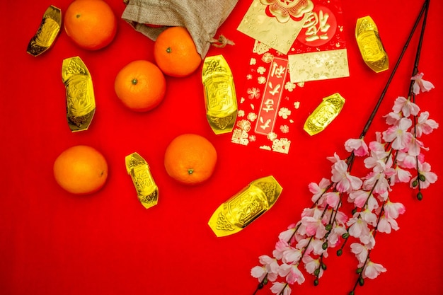 Bovenaanzicht accessoires van Chinees nieuwjaar of Mood day festival sinaasappels goud en Angpao zakken met kersenbloesem tak decoraties.