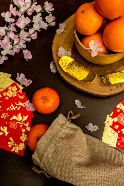 Bovenaanzicht accessoires van Chinees nieuwjaar of Mood day festival sinaasappels goud en Angpao zakken met kersenbloesem tak decoraties.