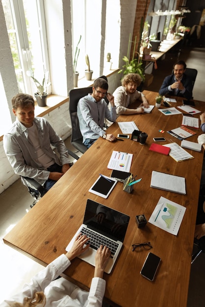 Bovenaanzicht afbeelding van gemotiveerde werknemers die samenwerken op kantoor Concept van zakelijke brainstormdeadlines