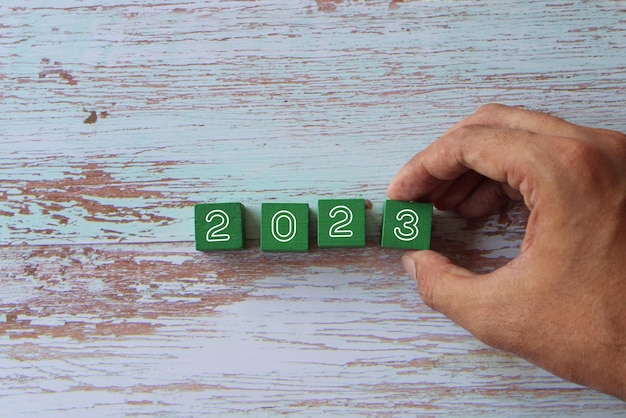 Bovenaanzicht afbeelding van hand houten kubussen rangschikken met nummers 2023 Nieuwjaar concept