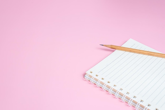 Foto bovenaanzicht afbeelding van notebook met potloden op roze achtergrond