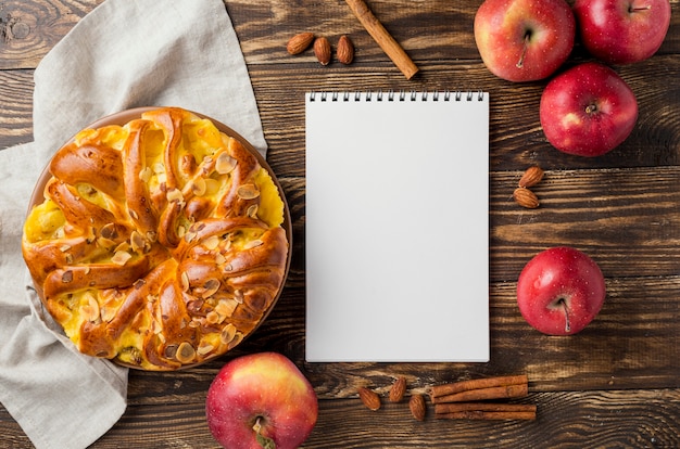 Foto bovenaanzicht appeltaart en fruit rond lege notitieblok