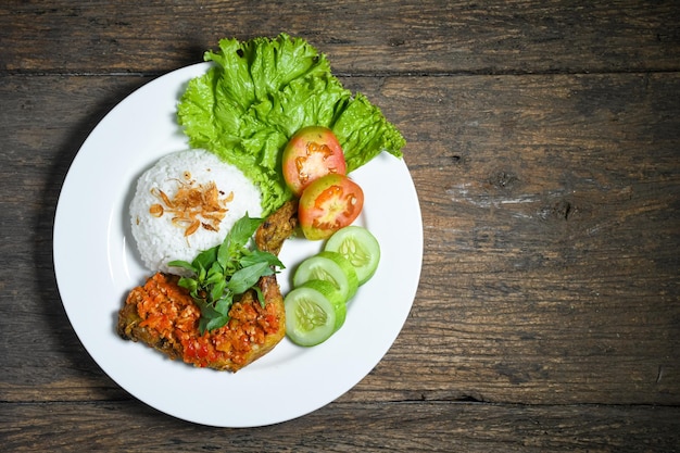 Bovenaanzicht Ayam geprek indonesisch eten met sambal hete chilisaus geserveerd rijst op witte plaat