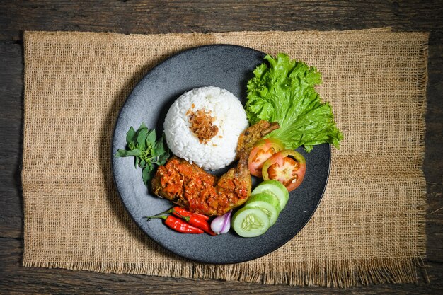 Bovenaanzicht Ayam geprek indonesisch eten of geprek gebakken kip met sambal hete chilisaus geserveerd rijst